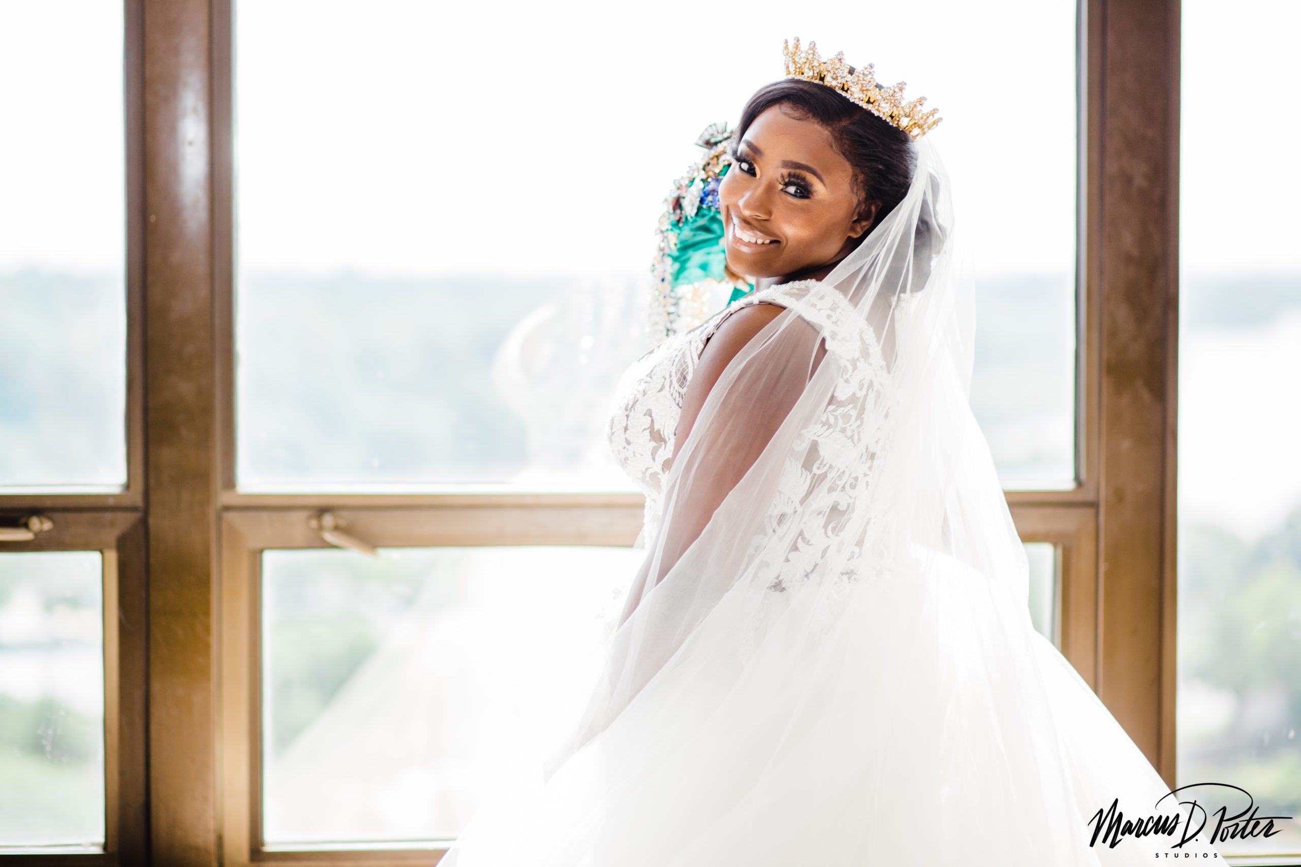 Sharon standing by the window at the Crowne Plaza Hotel in Camden, NJ for her Bridal Portraits